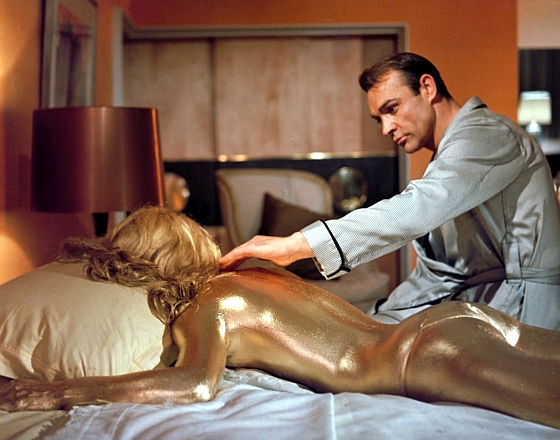 A dubai Goldfinger verzióban James Bond félmeztelen nő helyett arany PlayStation 4-et simogat.
